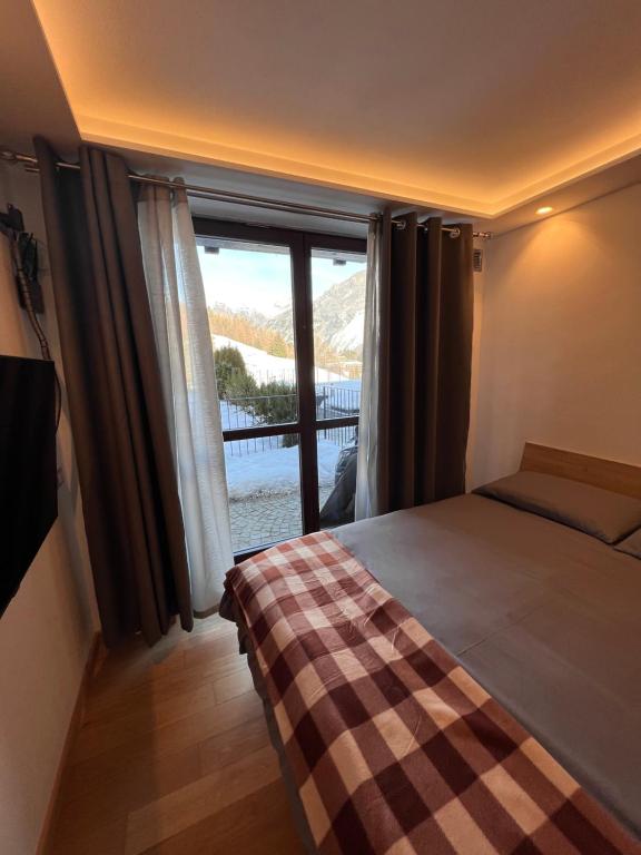 a bedroom with a bed and a large window at Elegante e moderno monolocale in Oga