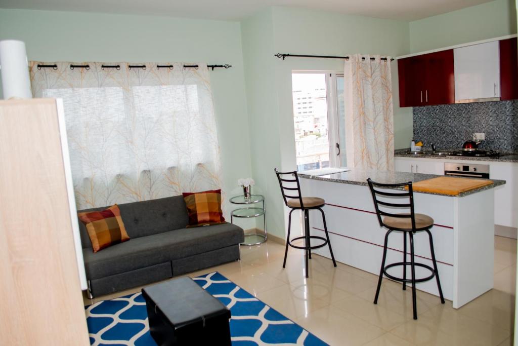 a kitchen and living room with a couch and a table at Comfortable and Cozy Apartments in Praia