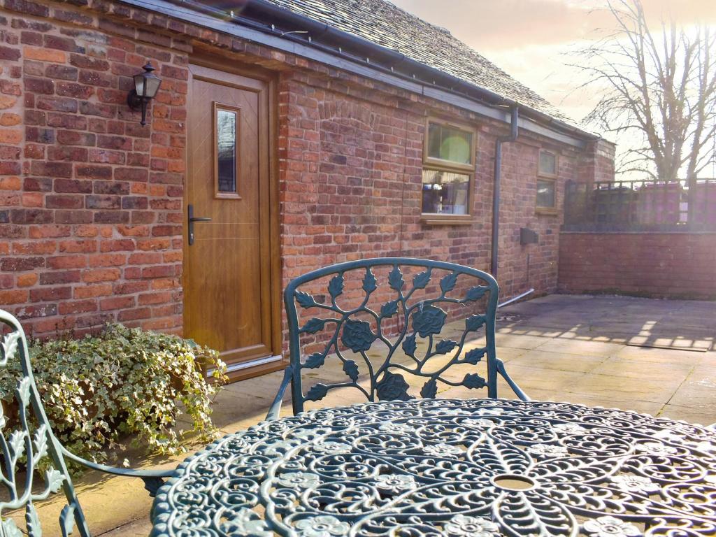 un patio con tavolo e sedia in ferro battuto. di The Byre - Uk42872 a Burntwood