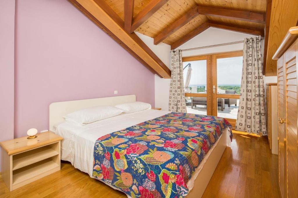 a bedroom with a bed with a colorful blanket at Apartment Zlendic in Gornje Selo