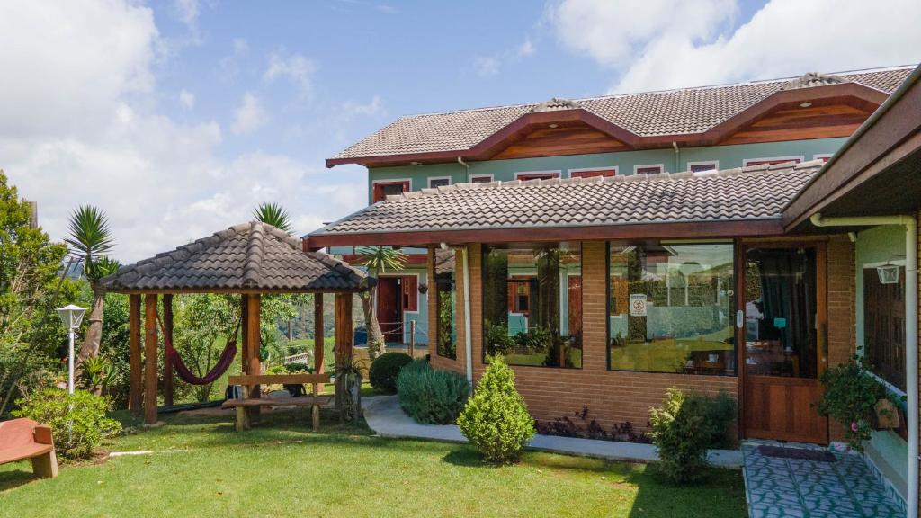 a house with a gazebo in a yard at Pousada Araucária Village in Campos do Jordão