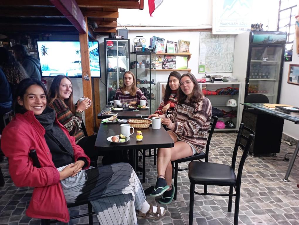un grupo de mujeres sentadas en una mesa en un restaurante en Andes Hostel, en Huaraz