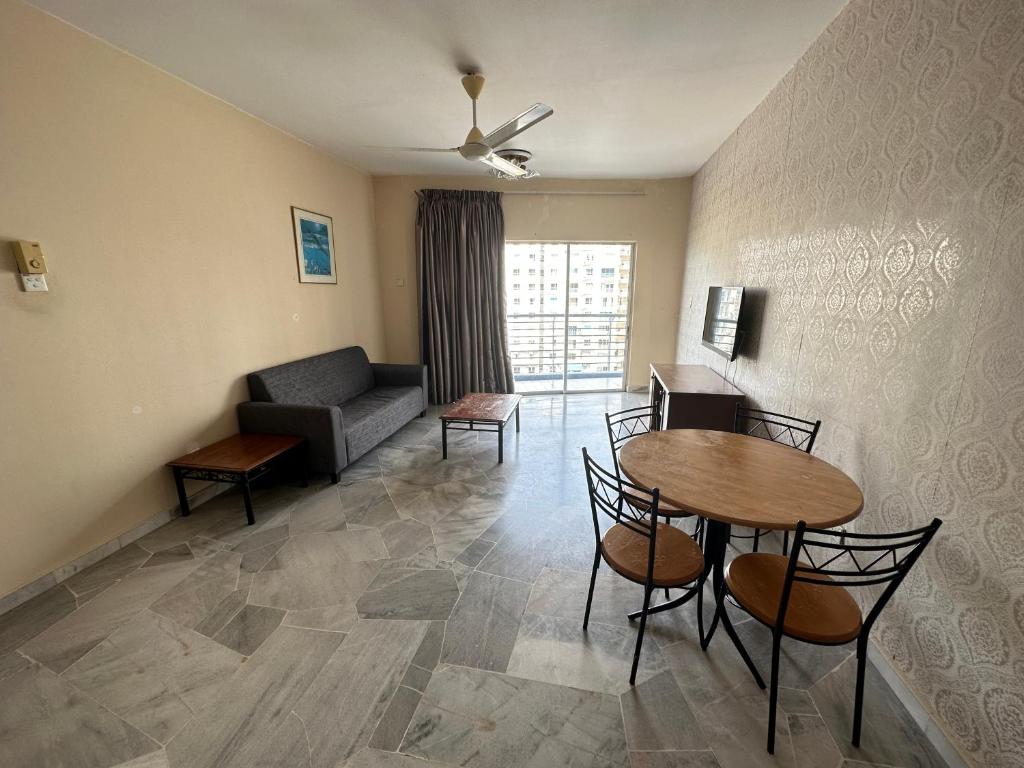 un salon avec une table, des chaises et un canapé dans l'établissement B7-2 @pd marina resort, à Port Dickson