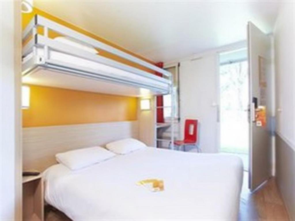 una camera con letto bianco di Premiere Classe Auxerre a Monéteau