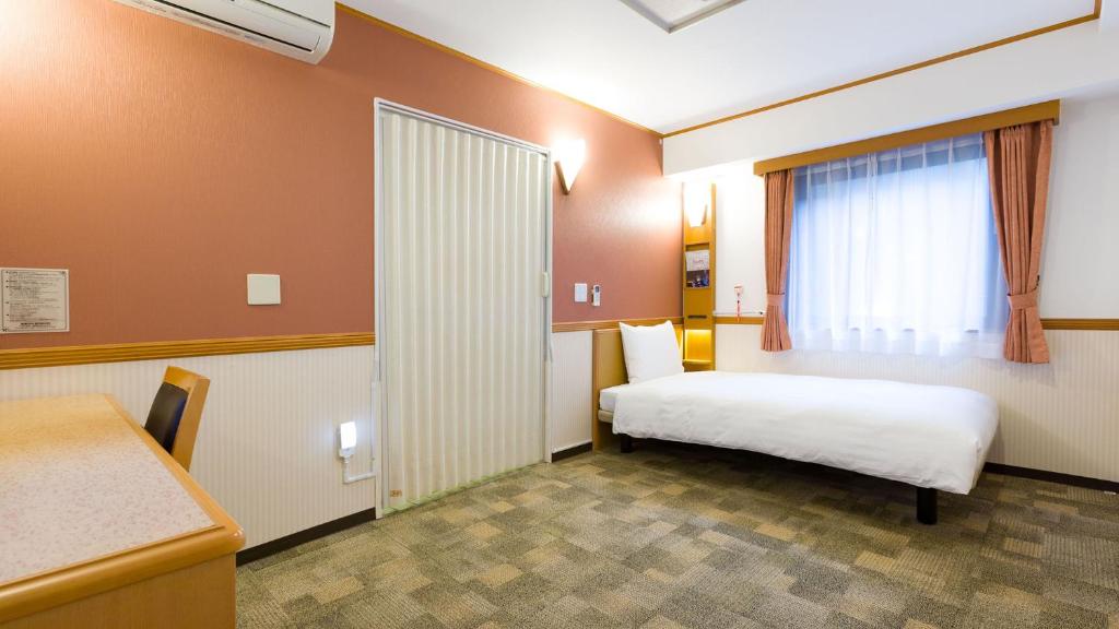 Postel nebo postele na pokoji v ubytování Toyoko Inn Yokohama Kannai