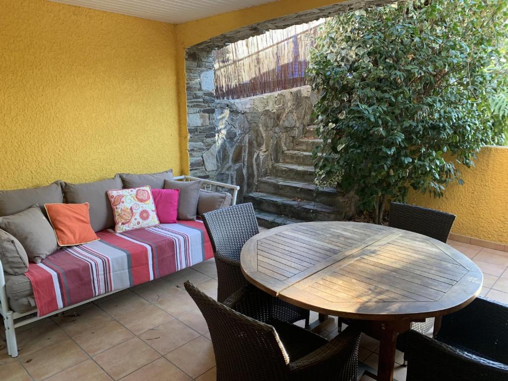 un patio avec un canapé, une table et des chaises dans l'établissement Appartement climatisé à Collioure : Terrasse, Wi-Fi, Piscine chauffée, Parking privé. - FR-1-309-143, à Collioure