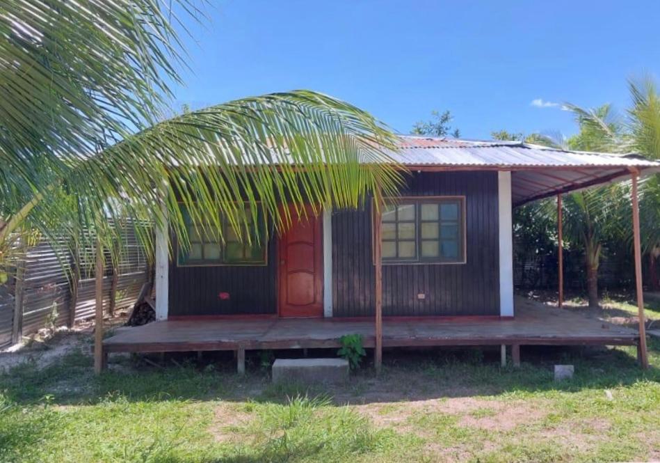 een klein huis met een rode deur en een veranda bij Cabaña para 4 in Iquitos