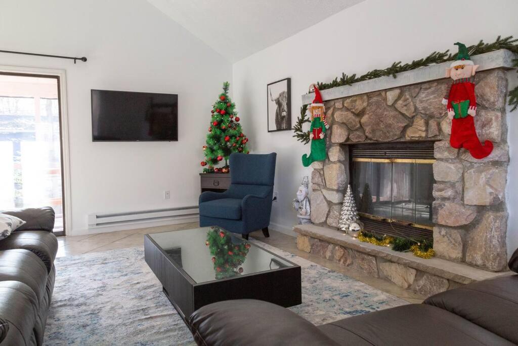 a living room with a fireplace with christmas decorations at Pocono Mountain Dream House near Camelback in Tobyhanna