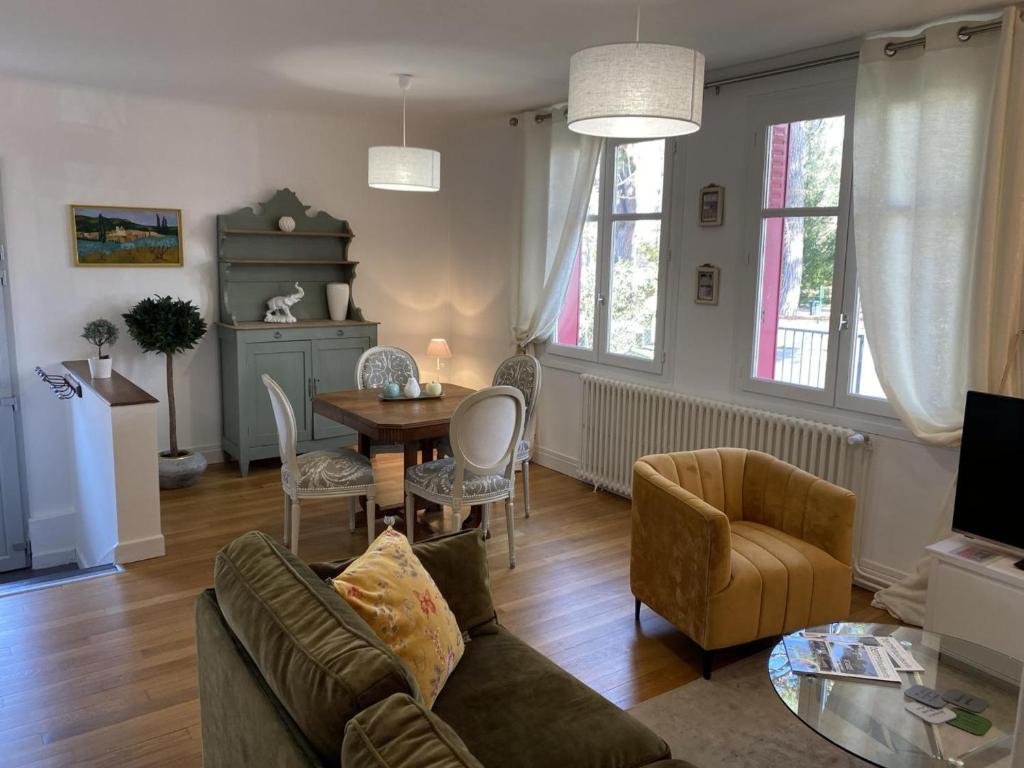 un soggiorno con un divano e un tavolo di Charmante maison avec jardin en face du parc, proche commerces et attractions touristiques - FR-1-489-333 a Moulins