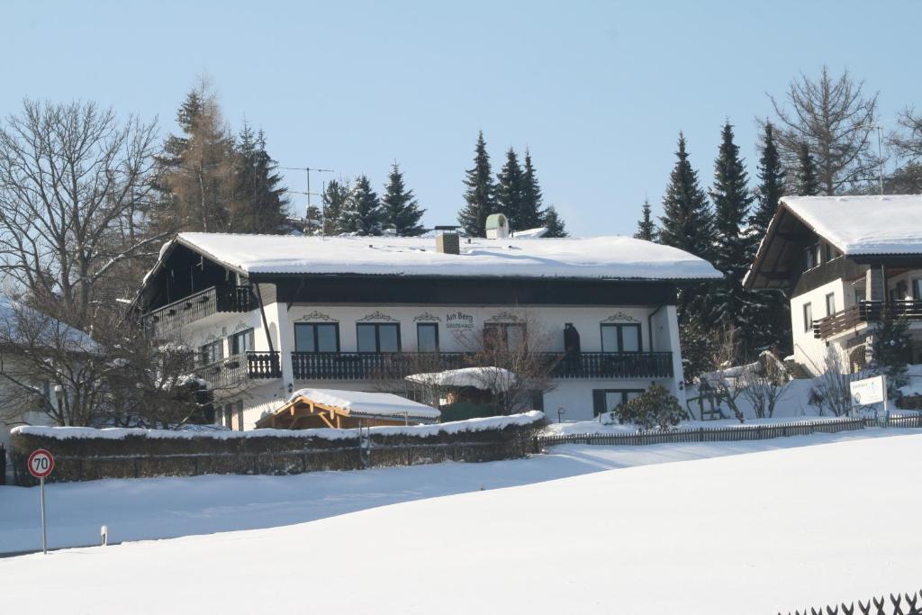 Una gran casa blanca con nieve encima. en Gästehaus am Berg en Bayerisch Eisenstein