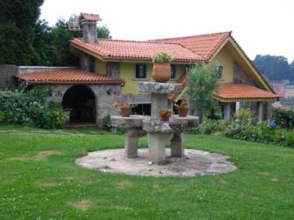 a house with a fountain in front of a yard at House - 3 Bedrooms with WiFi - 00075 in Bueu