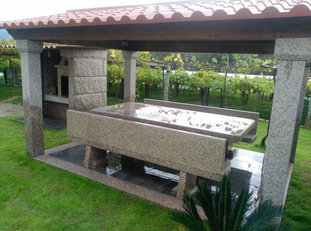 un banco de piedra bajo un cenador en House - 5 Bedrooms - 00174, en Cacabelos