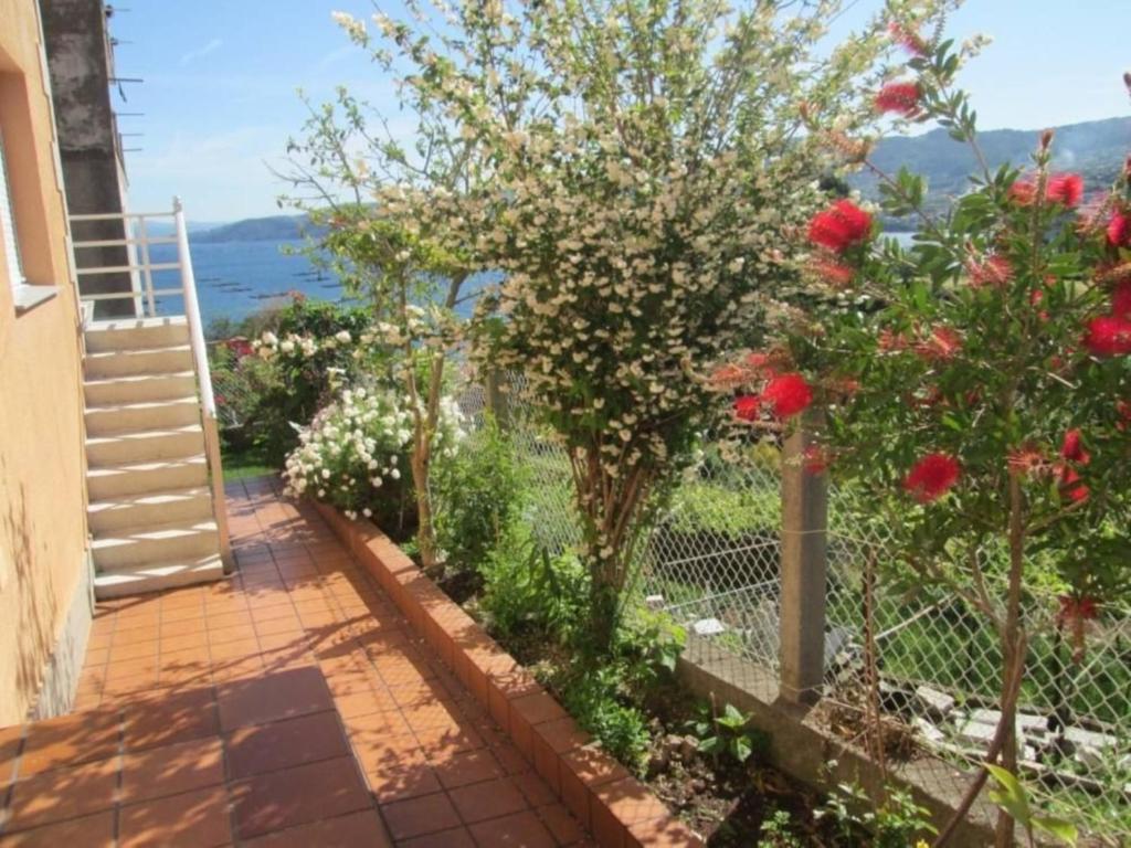 a garden with red flowers and a fence at Apartment - 2 Bedrooms with WiFi and Sea views - 01893 in Bueu