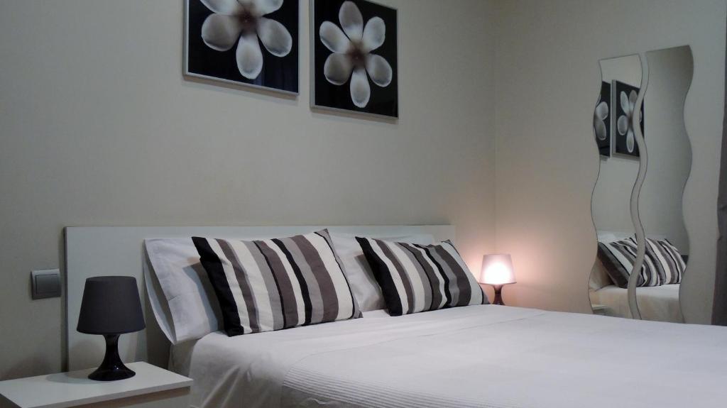 1 dormitorio con 1 cama blanca y 2 cuadros en la pared en Hostal Cervantes, en Madrid