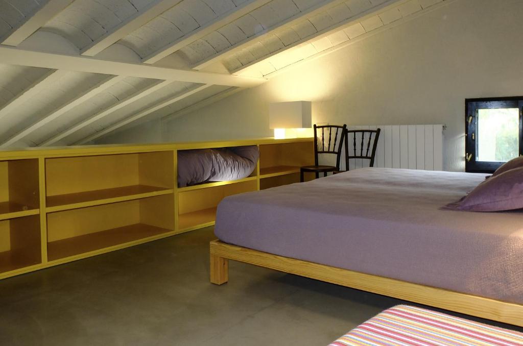 1 dormitorio con 1 cama y algunos estantes en Ca L'Olier, en Montblanquet