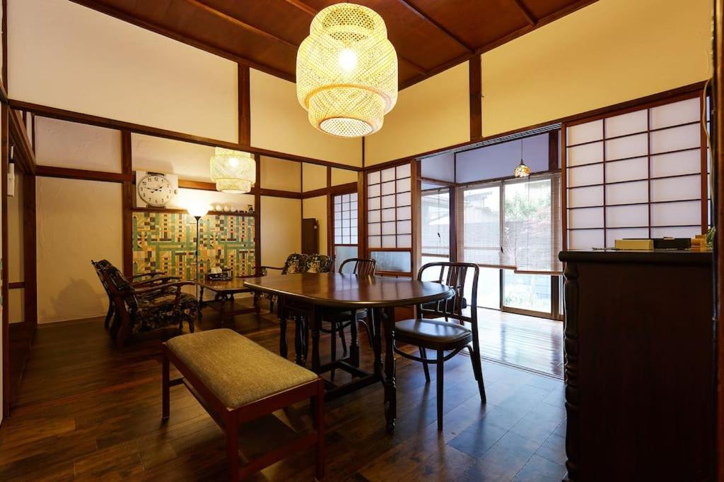 a dining room with a table and chairs and a chandelier at EK House Kamakura 鎌倉 Free Parking in Kamakura