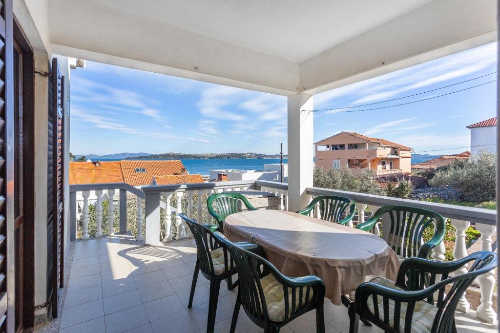 een balkon met een tafel en stoelen en uitzicht op het water bij Holiday home Milka - in center & close to the sea in Sali