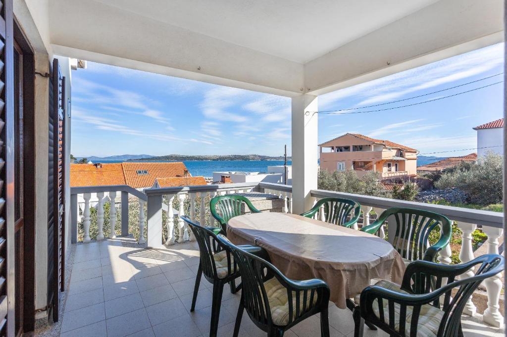 einen Balkon mit einem Tisch und Stühlen sowie Blick auf das Wasser in der Unterkunft Holiday home Milka - in center & close to the sea in Sali