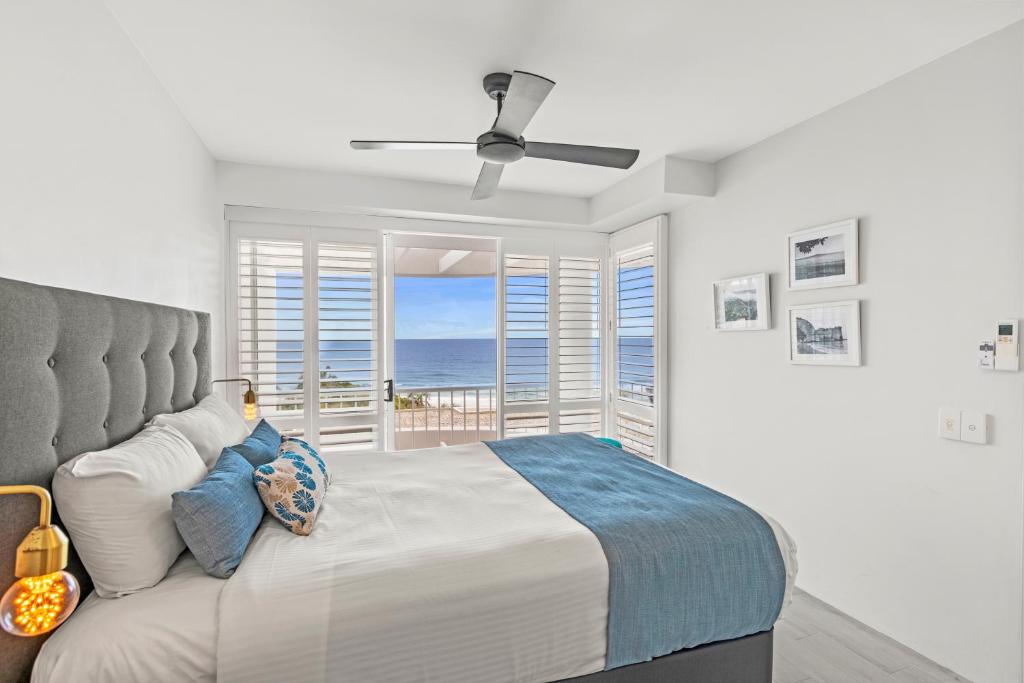 a bedroom with a bed and a view of the ocean at La Mer Sunshine Beachfront in Sunshine Beach