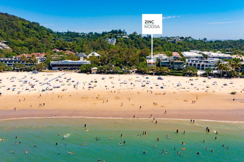 a group of people on a beach with a sign at Portofino 1 in Noosa Heads