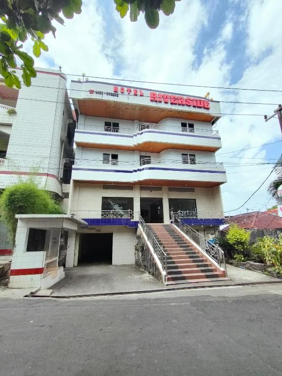 a building with a staircase in front of it at Hotel Riverside Manado in Manado