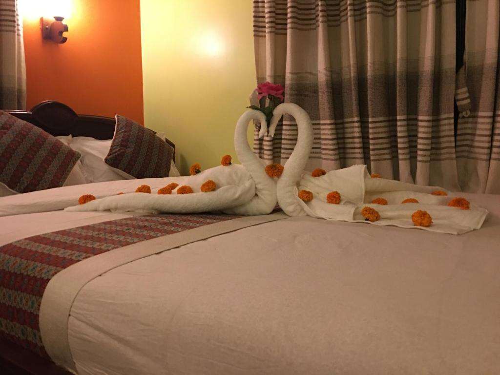 two swans made out of towels on a bed at Sweet Home in Chitwan