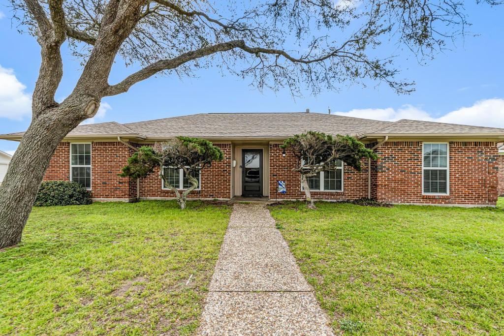 a brick house with a tree in front of it at Dolphin Lodge in Galveston