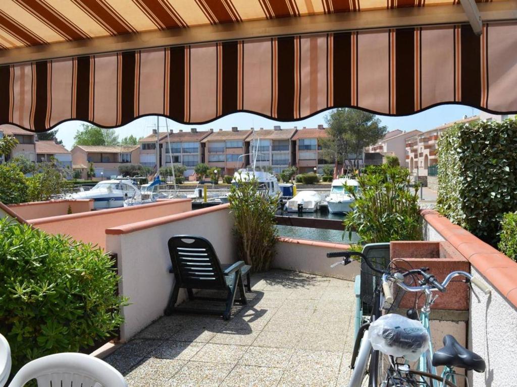 une terrasse avec une table, une chaise et un vélo dans l'établissement Appartement climatisé avec terrasse dans quartier animé, parking privé - FR-1-225D-573, à Saint Cyprien Plage