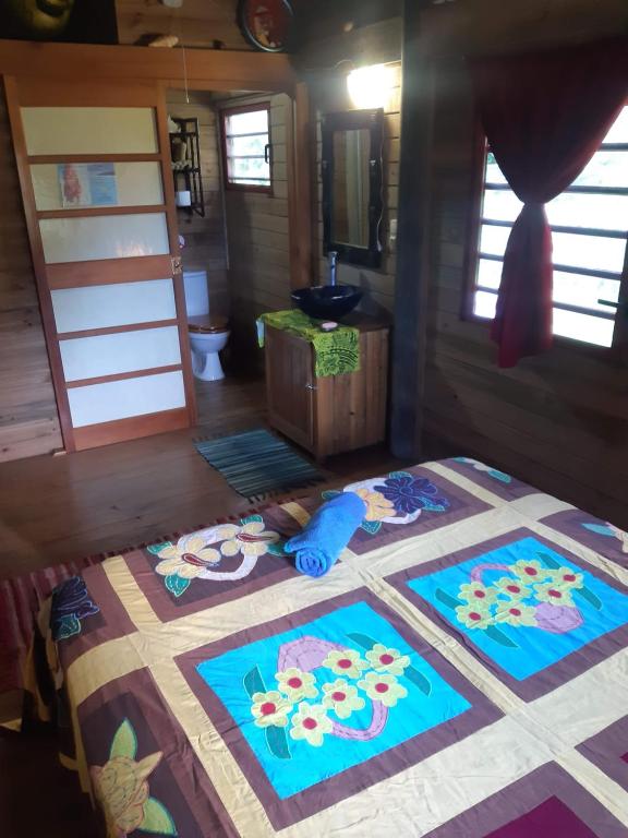 a bedroom with a quilt on a bed in a room at B & Bee Wild Island - Nature Song in Fare