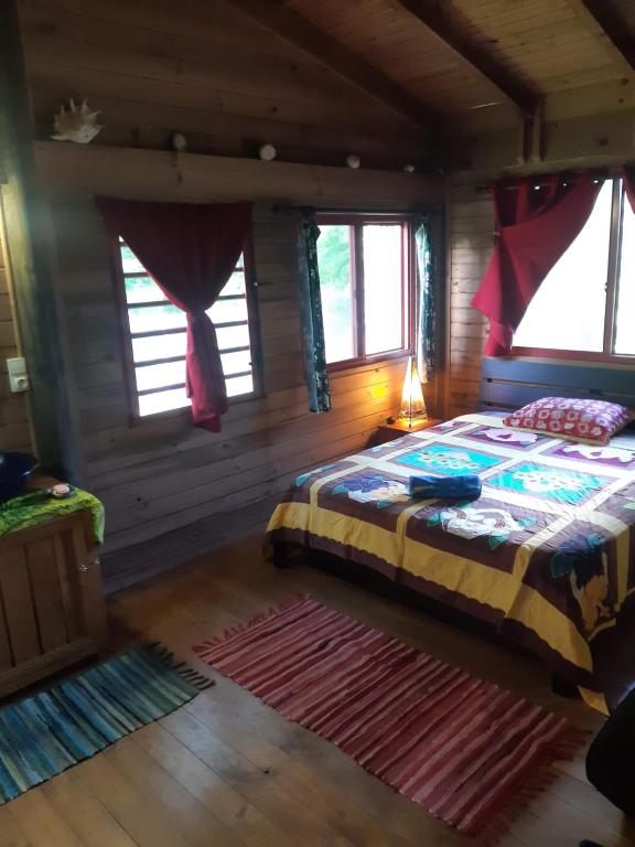 a bedroom with a bed in a log cabin at B & Bee Wild Island - Nature Song in Fare
