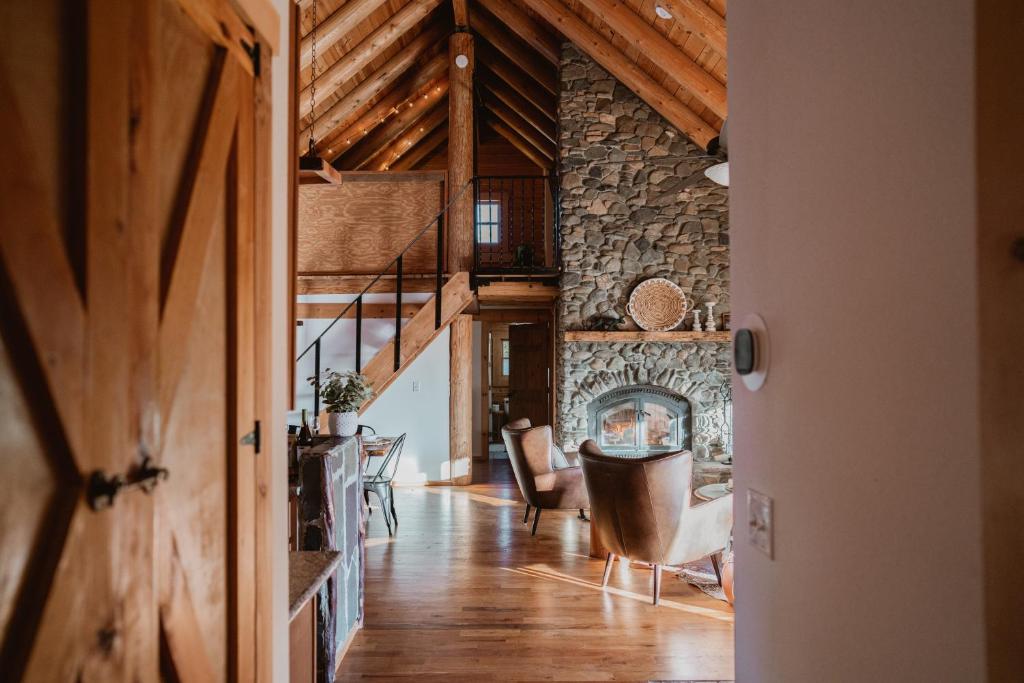 a living room with a stone wall and a fireplace at Yosemite Charm by Casa Oso with spa and breathtaking views in Mariposa