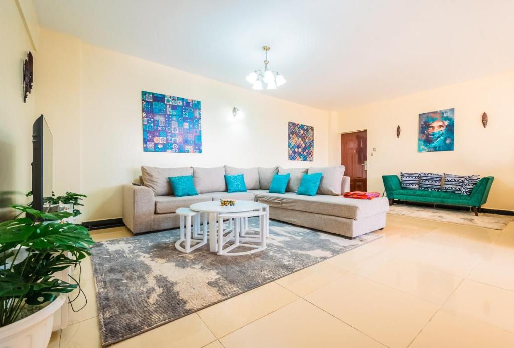 uma sala de estar com um sofá e uma mesa em Art-inspired 3BR Apartment em Nairobi