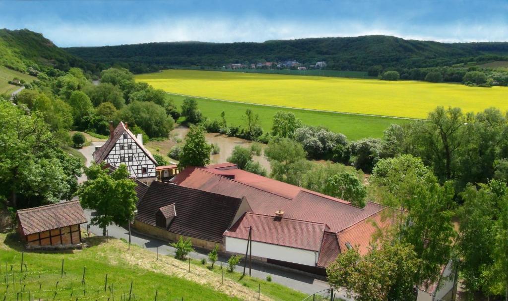 einen Blick über einen Bauernhof mit Häusern und Bäumen in der Unterkunft Ferienwohnung Weingut Kloster Pforta in Naumburg