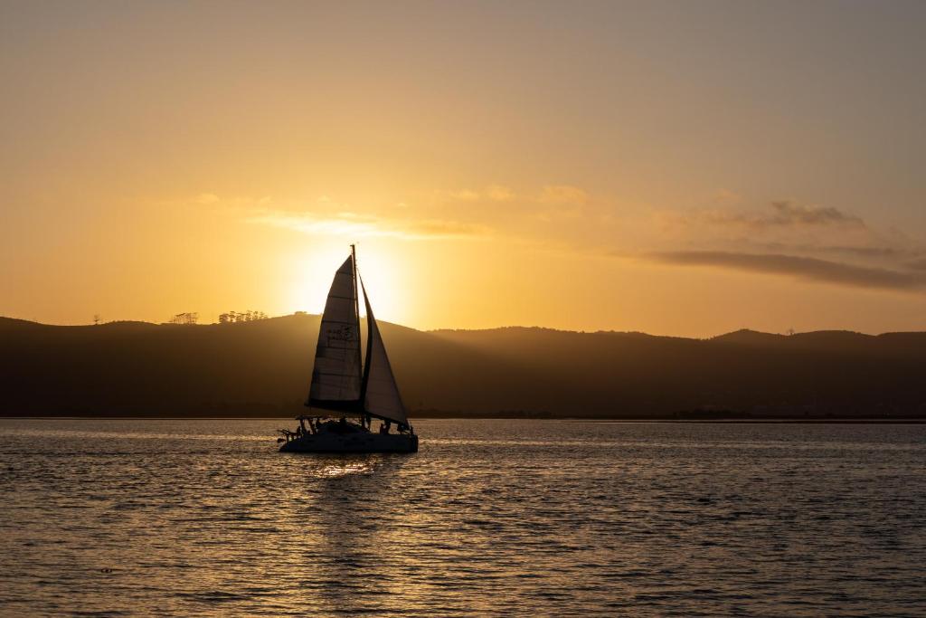 a sailboat in the water at sunset at The Lofts Boutique Hotel in Knysna