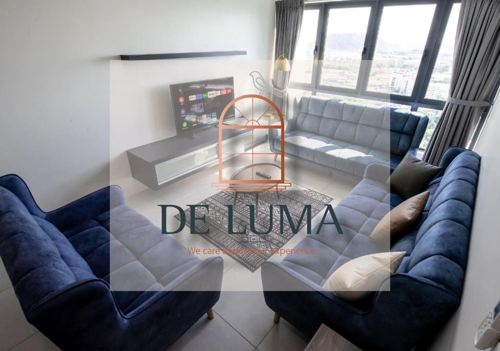 a living room with two blue chairs and a couch at De Luma - Meritus in Perai