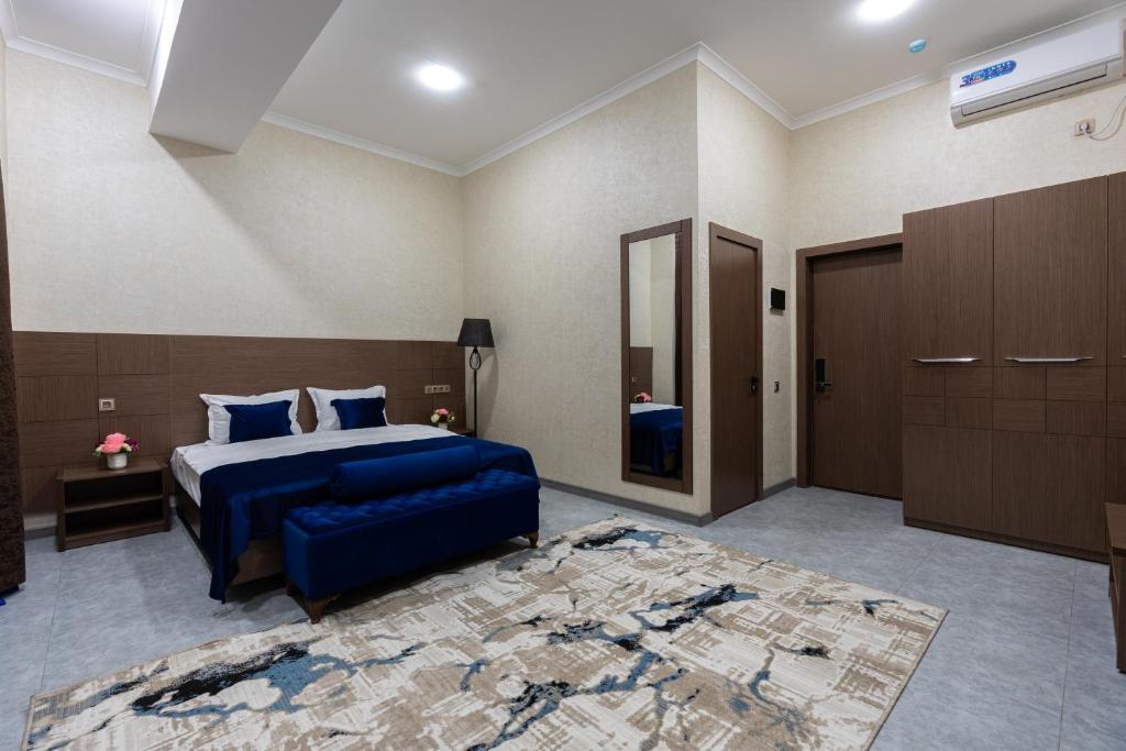 a bedroom with a blue bed and a blue couch at ABIS Palace Hotel in Tashkent