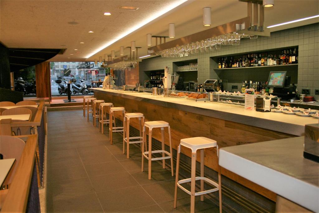 un restaurante con un bar con taburetes en Hotel Picos De Europa en Santander