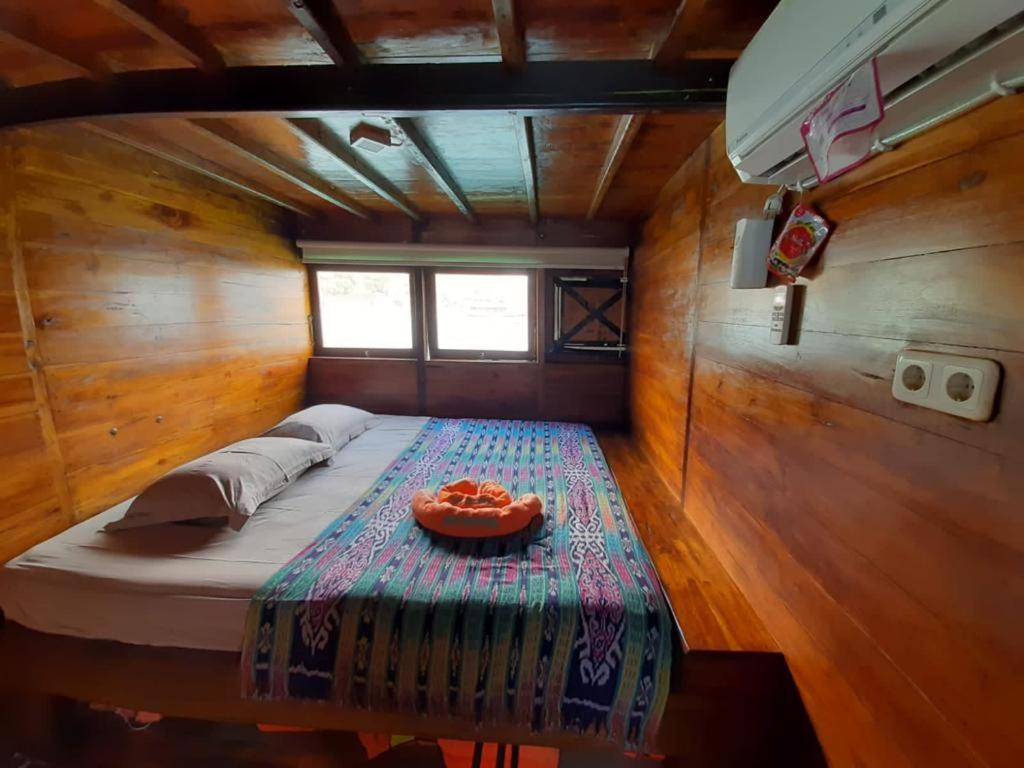 a bed in a wooden room with a bowl on it at Komodo Liveaboard 3 Days 2 Night in Labuan Bajo