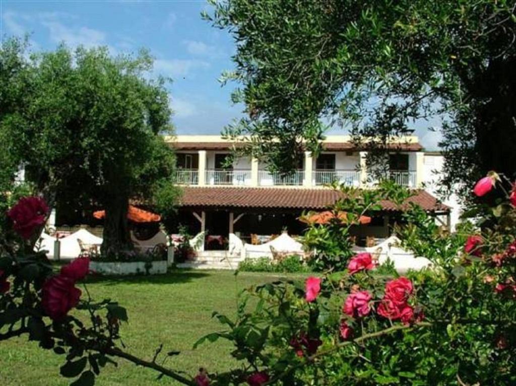 a large house with a yard with roses at Firefly Hotel in Moraitika