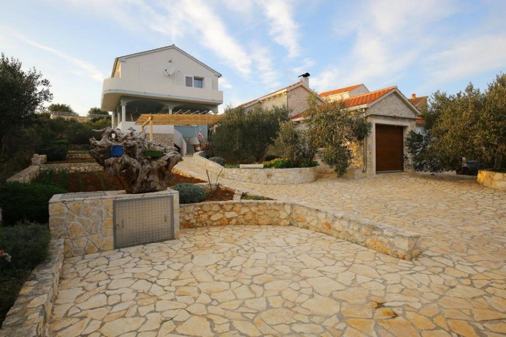 a stone patio in front of a house at House Lavanda in Premuda