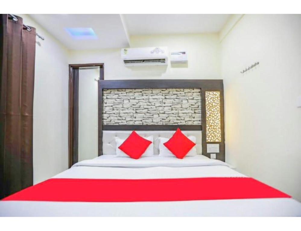 una camera da letto con un grande letto con cuscini rossi di Hotel Mrg Inn, Sri Ganganagar a Gangānagar