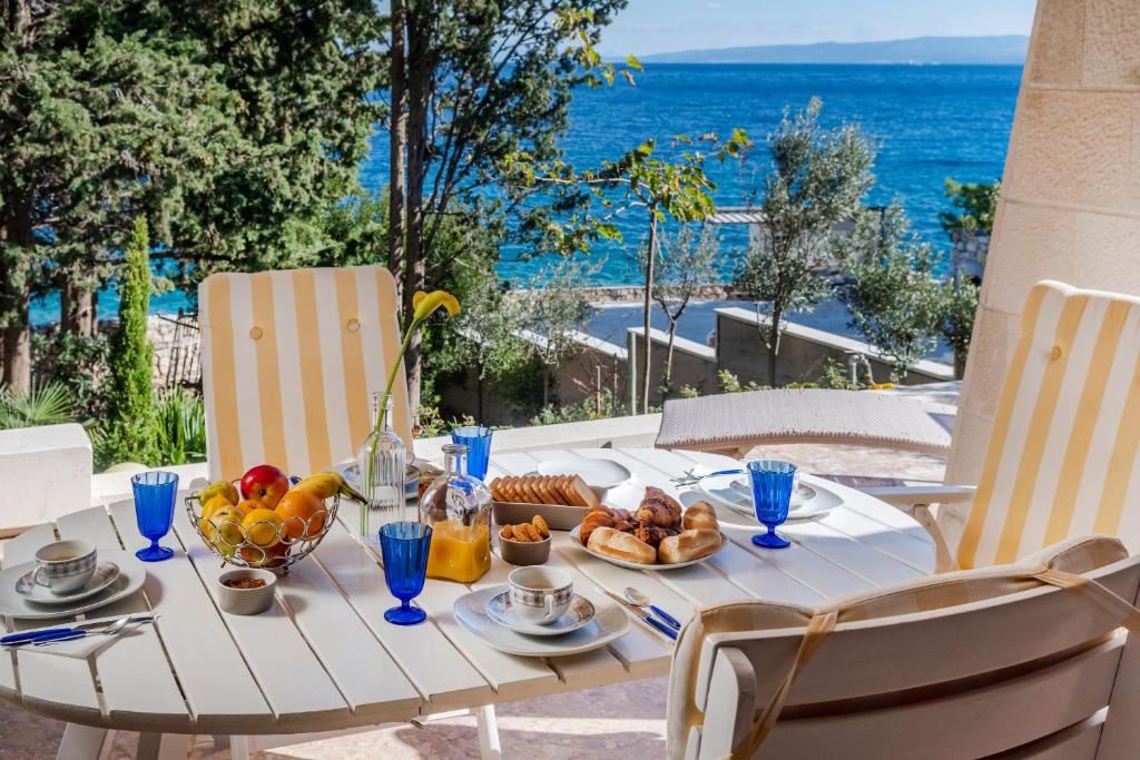- une table avec de la nourriture et une vue sur l'océan dans l'établissement Villa Vita, à Trogir