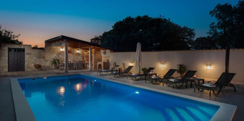 a swimming pool in a backyard at night at Villa Giardino in Drniš