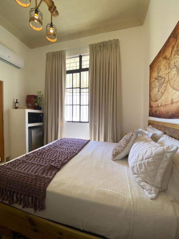 Un dormitorio con una cama grande y una ventana en Studio 27 Colonial, Centro Histórico, en Santo Domingo