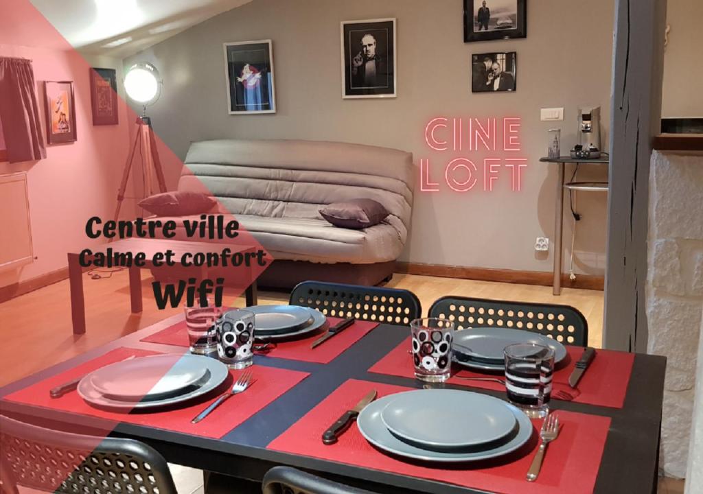 un salon avec une table et un tissu de table rouge dans l'établissement Ciné Loft 55 m2 Centre Ville, à Châlons-en-Champagne