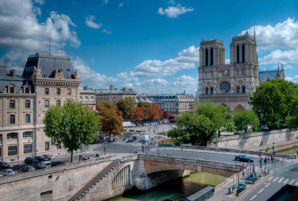 eine Brücke über einen Fluss in einer Stadt mit Gebäuden in der Unterkunft Les Rives de Notre-Dame in Paris