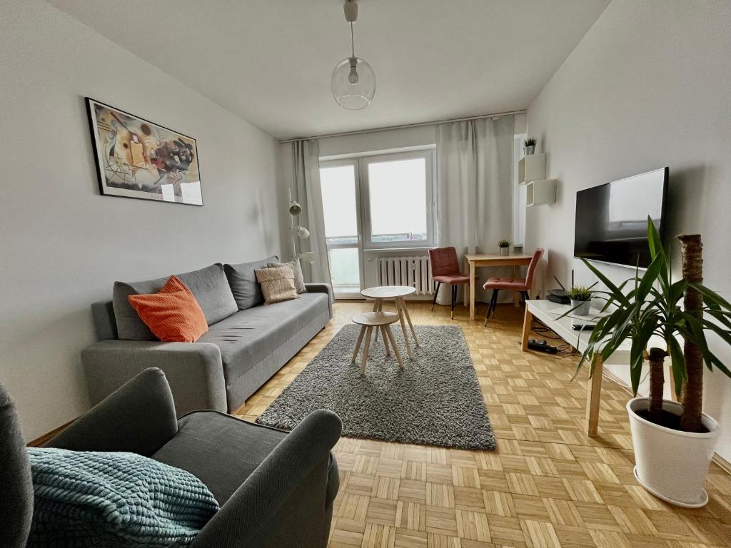 a living room with a couch and a table at Nest Optima Toruń in Toruń