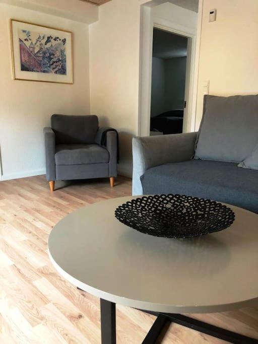 ein Wohnzimmer mit einem Tisch und einem Sofa in der Unterkunft Lejlighed i midtby - tæt på alt in Viborg