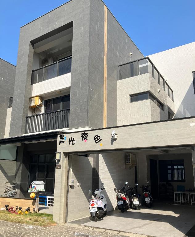 a building with two motorcycles parked in front of it at 晨光夜色 in Magong