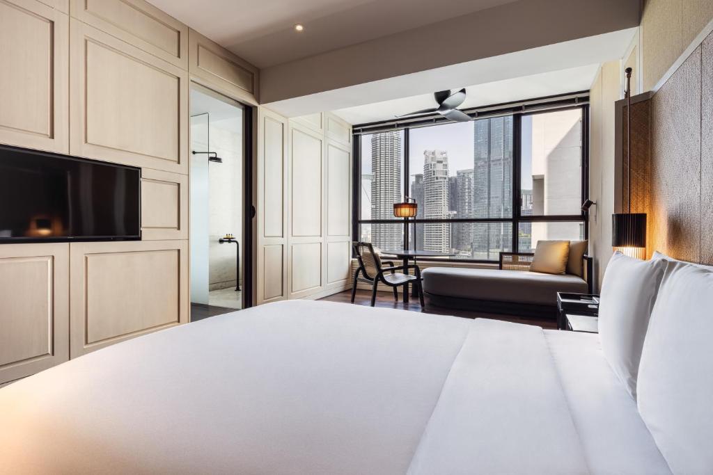 A bedroom and sitting area with a broad city-facing window.